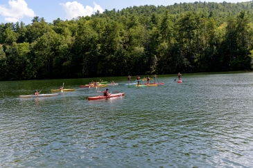 High school students gather on kayaks and paddle boards to start the race.